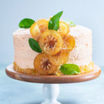 This orange cake is infused with real oranges, an orange buttercream and garnished with candied citrus slices and peel. | tchakayiti.com